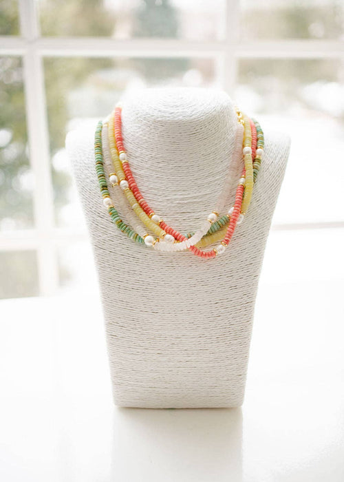 Necklace on a mannequin bust with a blurred window background