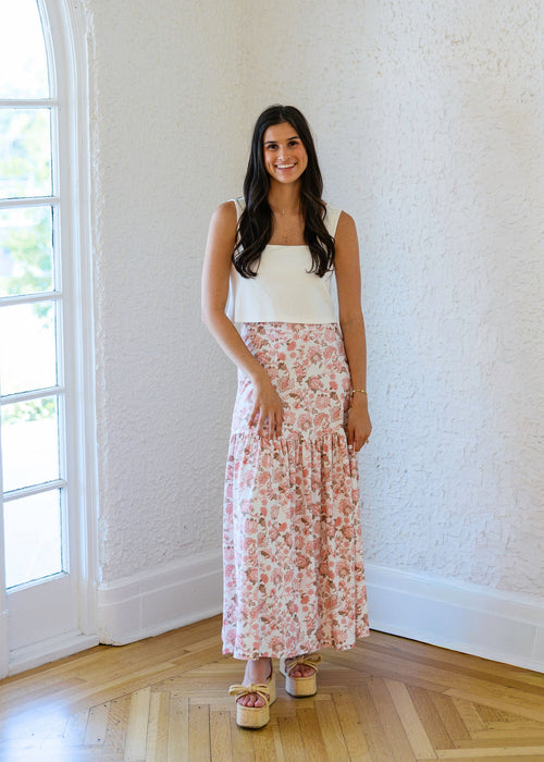 Woman standing in a room with white walls and wooden flooring