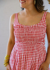 Woman wearing a red and white checkered dress with a plain background