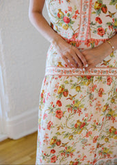 Person wearing a floral dress with a white background