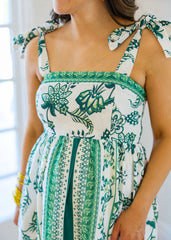 Woman wearing a green and white patterned dress indoors