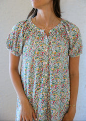 Woman wearing a floral dress against a plain background