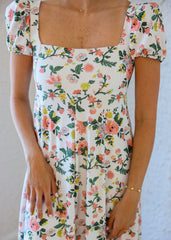 Woman wearing a floral dress with a plain background