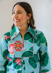Woman wearing a colorful floral patterned shirt against a white background