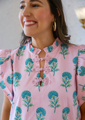 Woman wearing a pink floral blouse with a white background