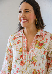 Woman wearing a floral blouse with a plain background