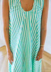 Person wearing a green and white striped dress with a blurred background