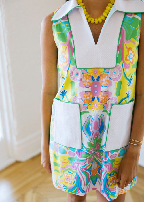 Colorful floral dress with a white collar worn by a person indoors.