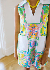 Colorful floral dress with a white collar worn by a person indoors.