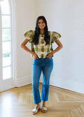 Woman standing in a room with large windows and white walls