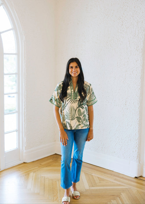 Woman standing in a room with white walls and wooden floor