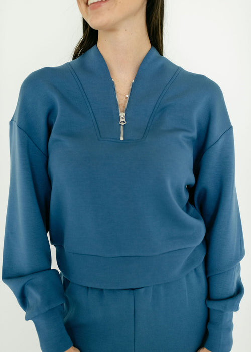 Person wearing a blue outfit with a zipper detail on a white background