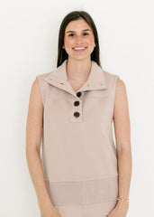 Woman wearing a beige sleeveless vest with buttons on a white background