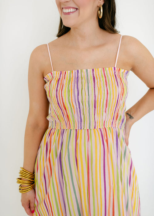 Woman wearing a colorful striped dress against a white background
