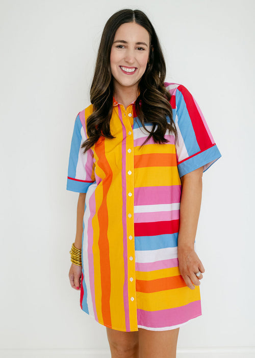 Woman wearing a colorful striped dress against a white background