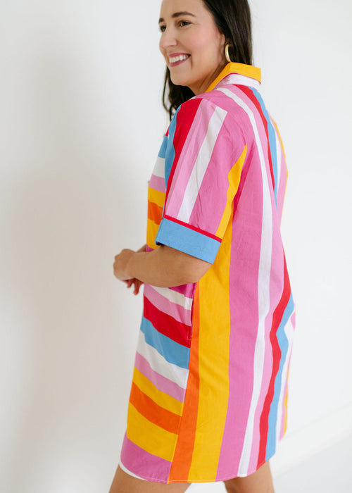Woman wearing a colorful striped dress against a white background