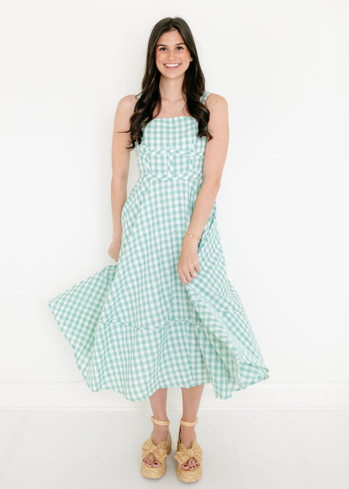 Woman wearing a green checkered dress on a white background