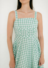 Woman wearing a green checkered dress against a white background
