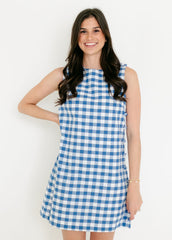 Woman wearing a blue and white checkered dress against a white background