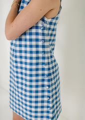 Blue and white checkered dress worn by a person on a plain background
