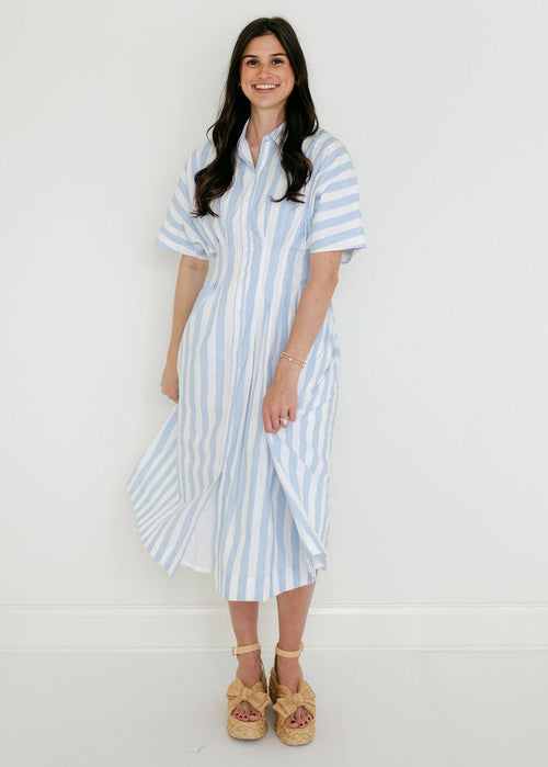 Woman wearing a blue and white striped dress against a white background
