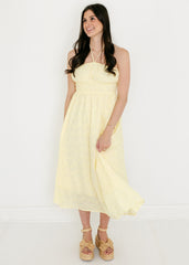Woman wearing a light yellow dress against a white background