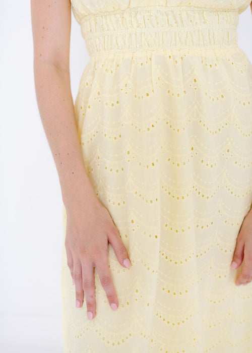 Yellow dress with a textured pattern on a white background