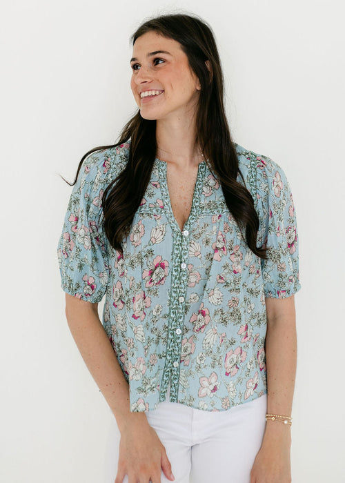 Woman wearing a floral blouse against a white background