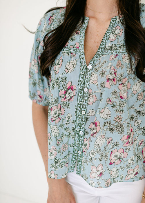 Floral patterned blouse worn by a person on a white background