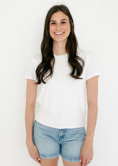 Woman wearing a white t-shirt and denim shorts on a white background