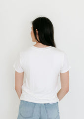 Person wearing a white t-shirt and light blue denim shorts on a plain background