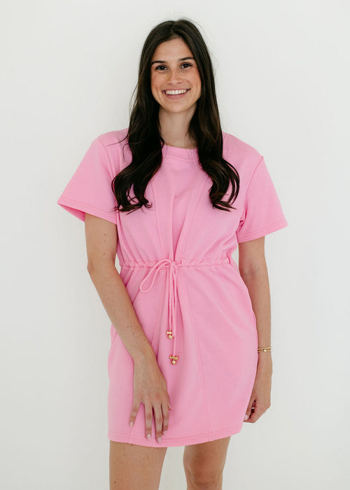 Woman wearing a pink dress against a white background