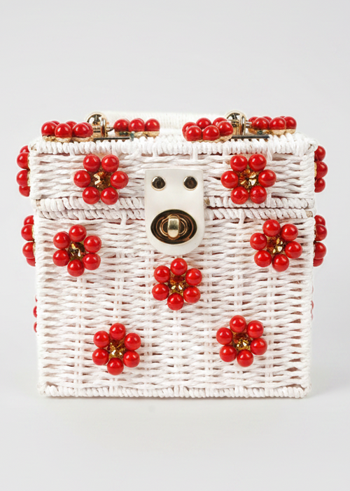 White woven handbag with red floral decorations on a light gray background