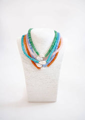 Colorful beaded necklaces on a white mannequin bust against a white background